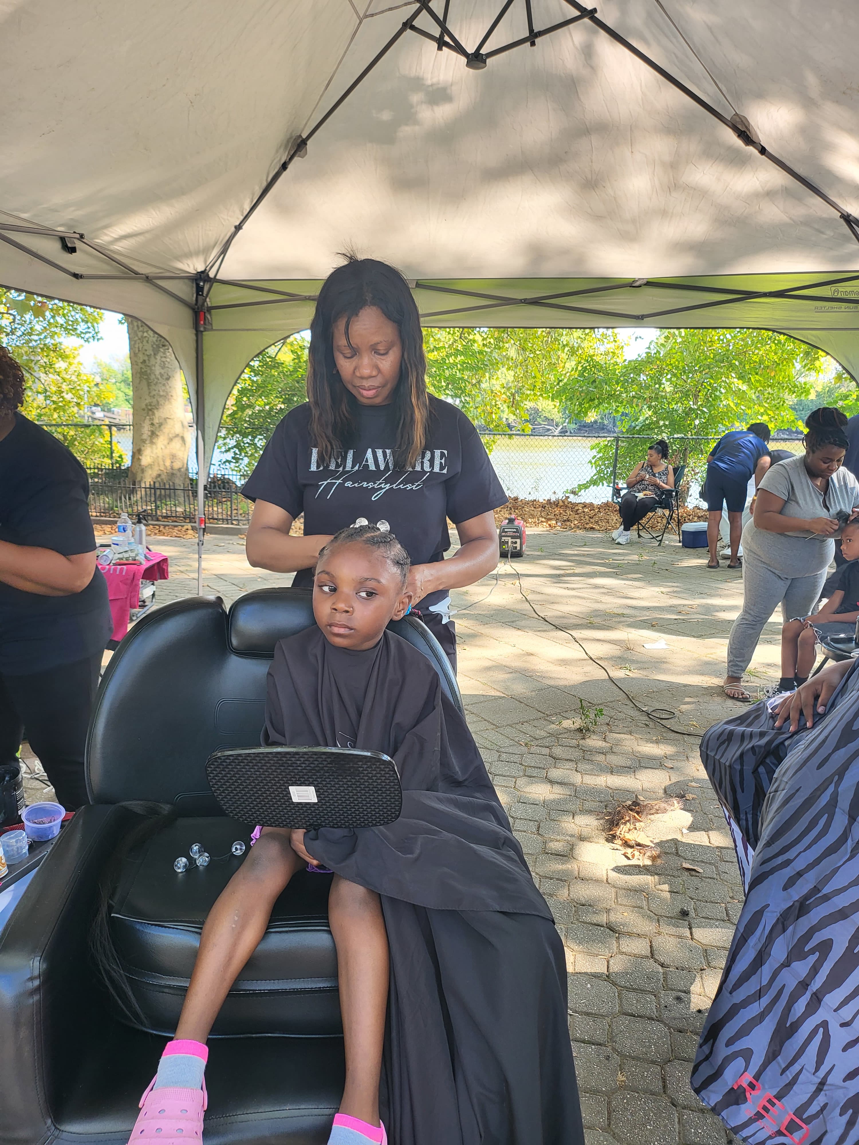 Sinkor stylist giving free haircut to young girl at community event
